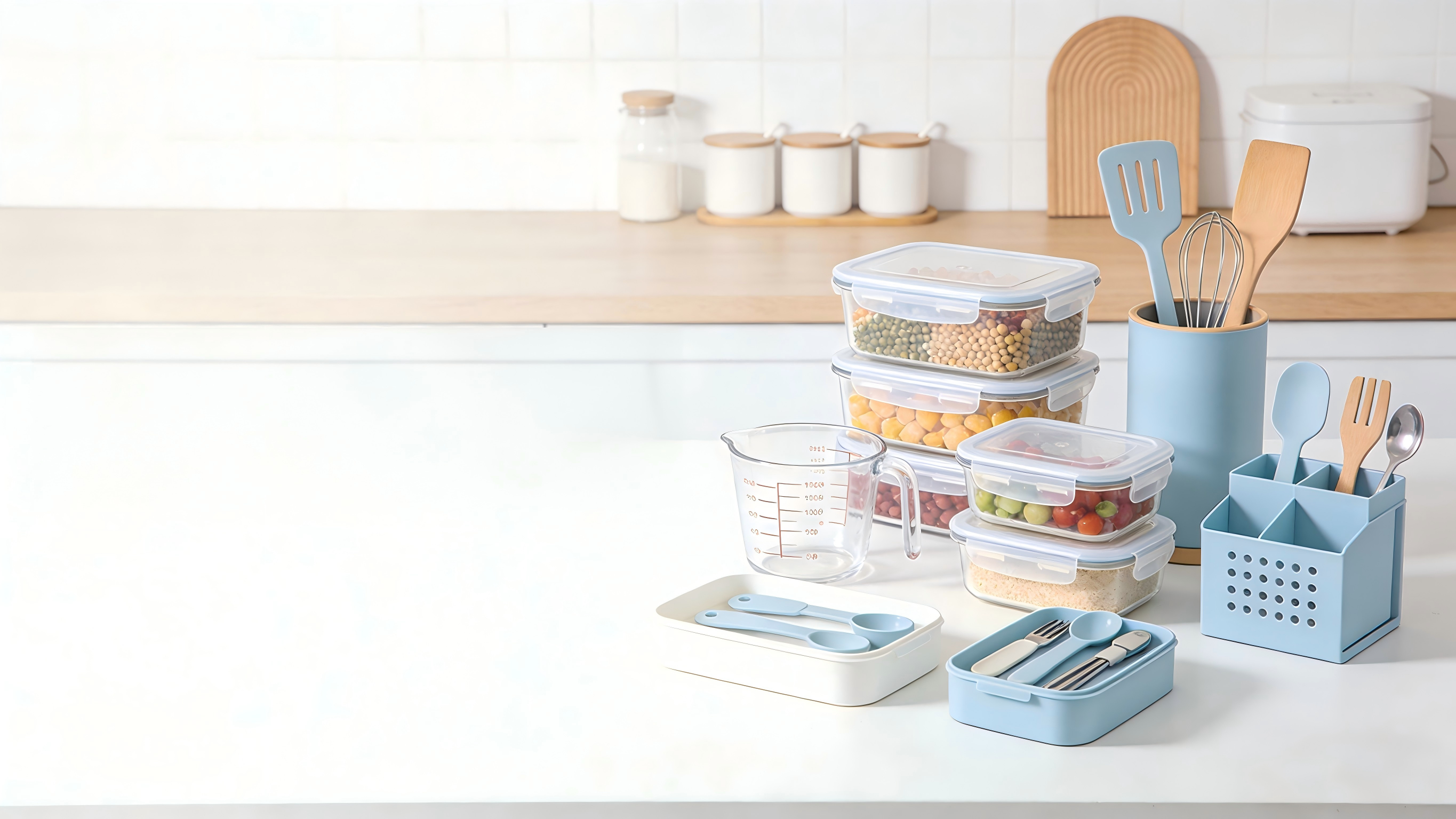 Kitchen counter with storage containers, measuring cups, and utensils on a light background